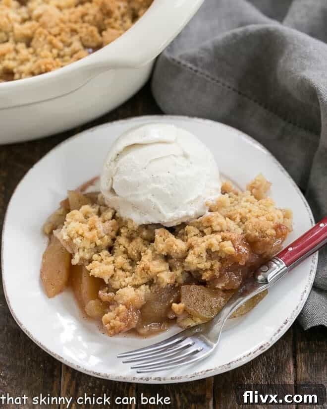 Easy Apple Crisp on a white plate topped with ice cream