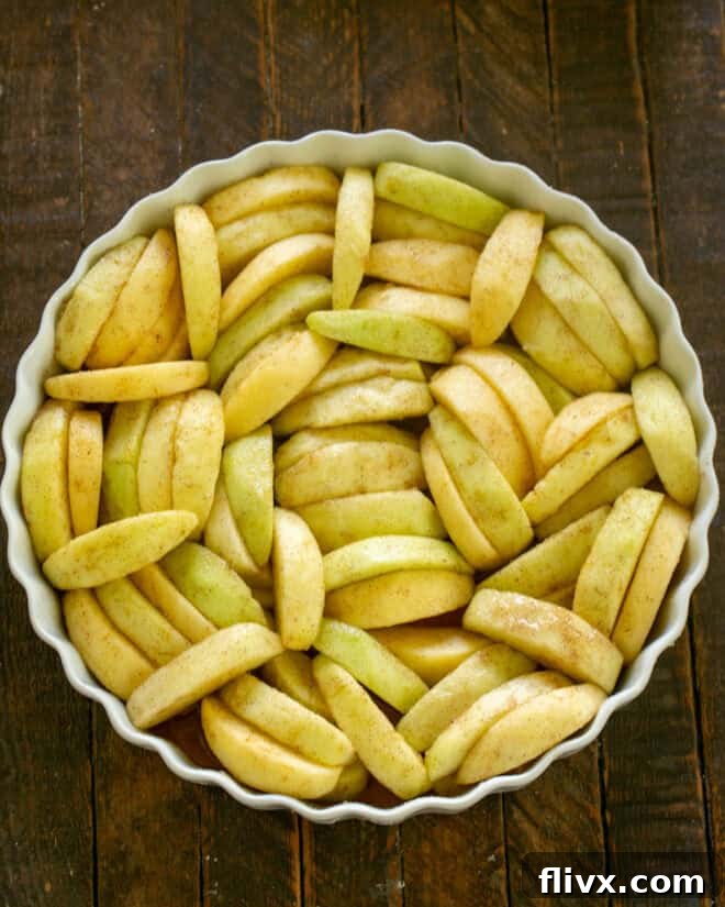 Prepared apple filling added to a baking dish.