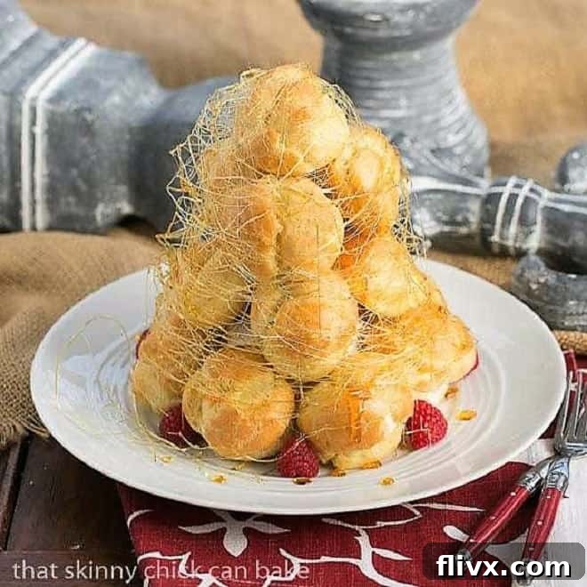 A stunning Lemon Cream Croquembouche stands proudly on a white serving plate, beautifully garnished with fresh, vibrant raspberries and delicate spun sugar, ready to impress.