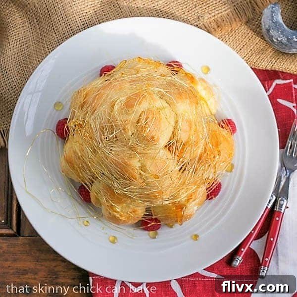 An overhead view of the exquisite Lemon Cream Croquembouche, showcasing its perfect conical structure and delicate spun sugar decoration, ready for serving.