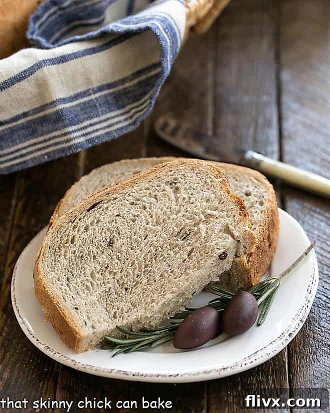 Rosemary Olive Bread slices on a white plate with fresh rosemary and olives