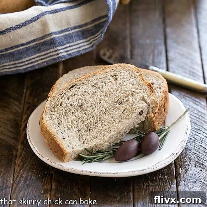 Sliced Rosemary Olive Bread on a small, white ceramic plate