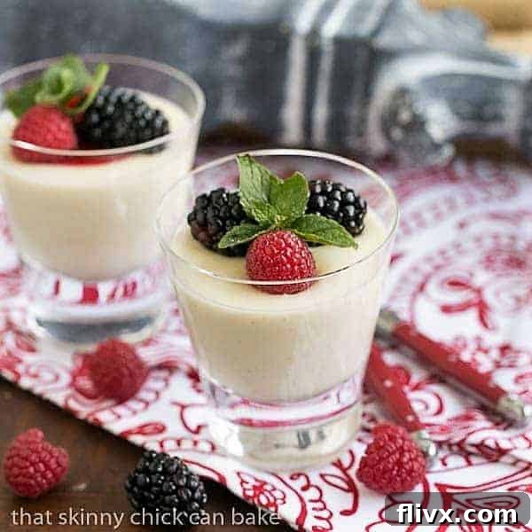 2 servings Vanilla Bean Panna Cotta garnished with berries and mint.