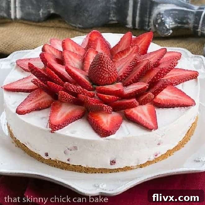 Strawberry Vanilla Cream Pie topped with fresh strawberry slices on a white Juliska serving plate, showcasing its exquisite presentation.