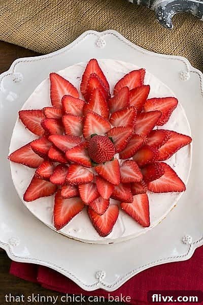 Overhead view of Strawberry Vanilla Cream Pie topped with an artful arrangement of fresh strawberry slices, ready to be served.