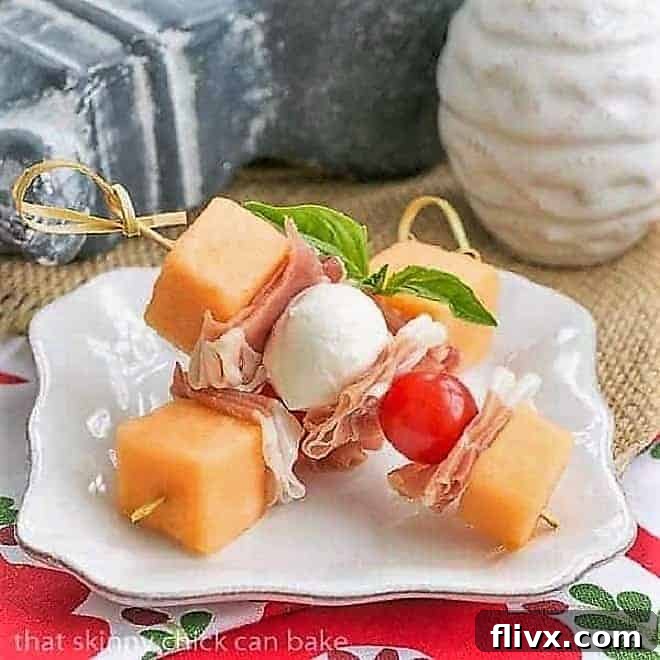 Exquisitely arranged Melon and Prosciutto Skewers on a small white appetizer plate, garnished with fresh basil leaves, ready to be served at an Italian-themed gathering.
