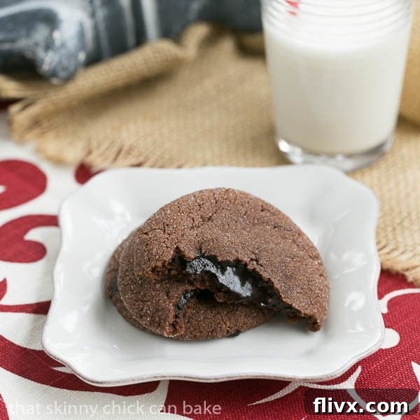 A chocolate lava cookie broken in half, revealing a rich, molten fudge filling oozing out.