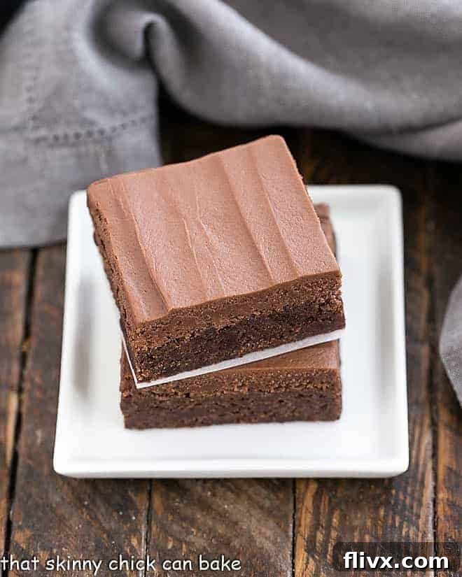 Cooled brownies frosted with a thick layer of chocolate buttercream, then cut into squares and served.