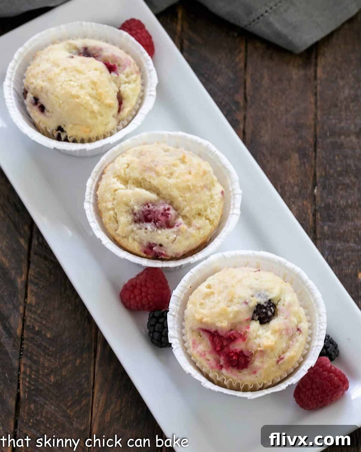 Overhead view of Mixed Berry Muffins on a white ceramic tray.