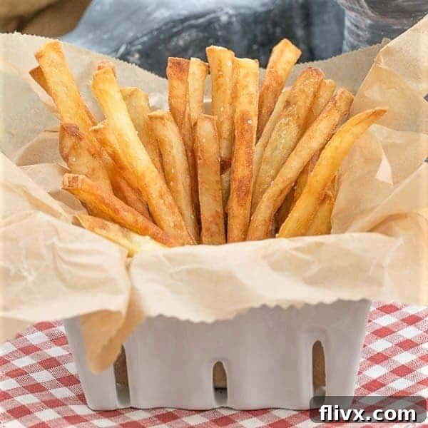 Thin Crispy French Fries - As good or better than McDonald's, but made in your own kitchen! Thin Crispy French Fries in a ceramic basket lined with parchment, ready to be served with dipping sauce.