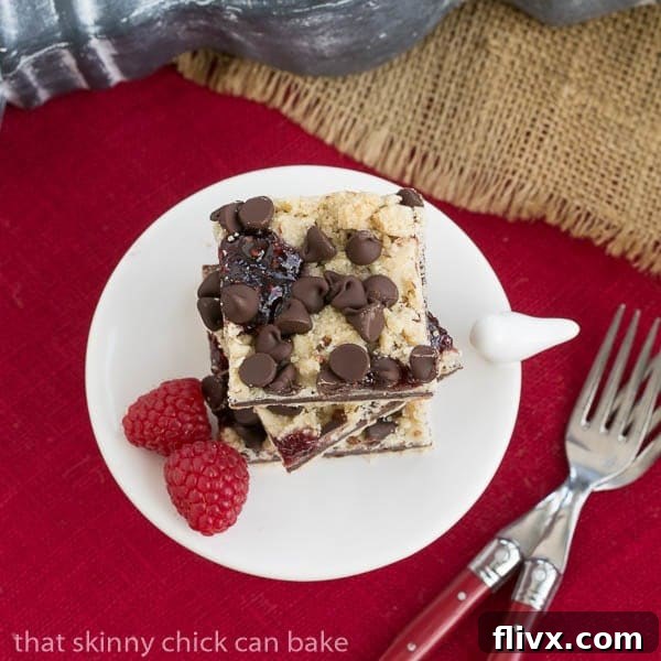 Overhead Chocolate Raspberry Crumb Bars on a white pedestal on a red napkin