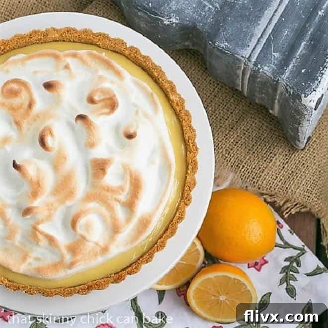 An overhead view of the Meyer Lemon Tart with Meringue Topping on a white cake stand, highlighting its perfect proportions