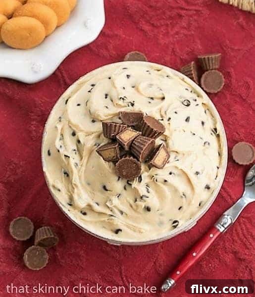 An inviting overhead view of a serving bowl filled with creamy Tagalong Dip, generously topped with an assortment of mini Reese's peanut butter cups, making it an irresistible dessert.
