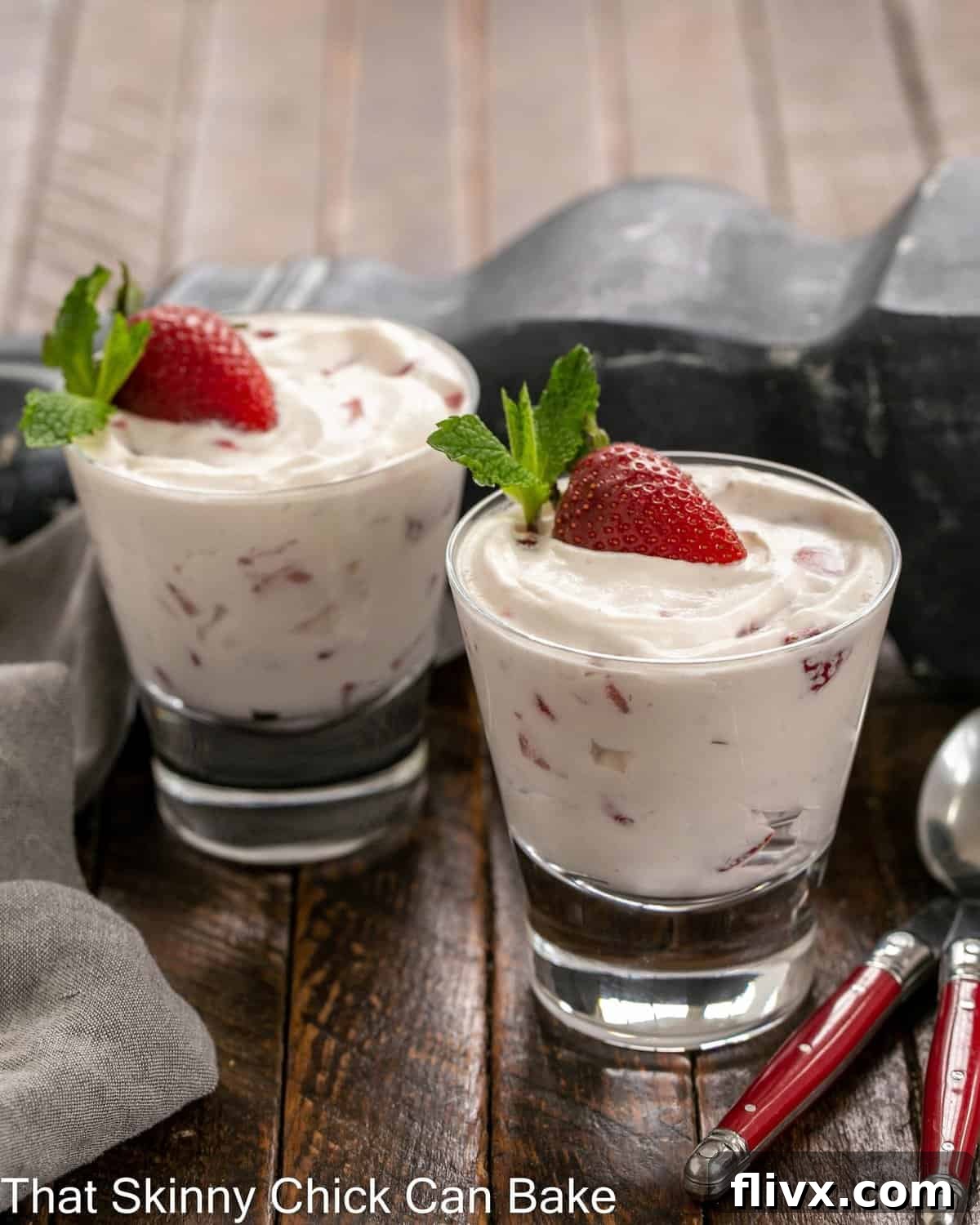 Two exquisite dishes of No-Bake Strawberry Fool, beautifully garnished with a half strawberry and a fresh mint sprig on each, ready to be served.