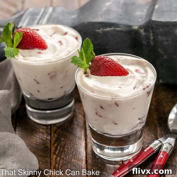 Two beautiful servings of No-Bake Strawberry Fool, each adorned with a fresh half-strawberry and a vibrant sprig of mint, presented in elegant glass dishes.