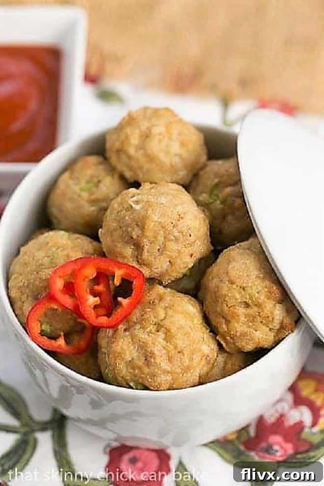 Sesame Ginger Meatballs beautifully arranged in a white lidded serving dish, ready to be enjoyed.