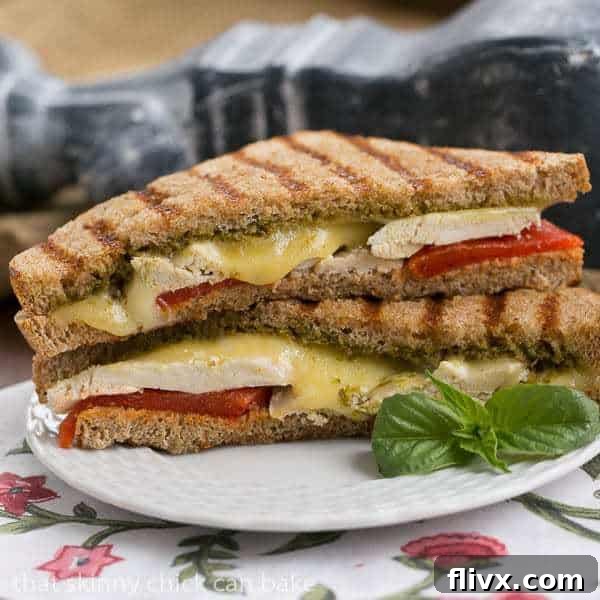 A beautifully presented Chicken Pesto Grilled Cheese sandwich, golden brown and oozing with melted cheese.