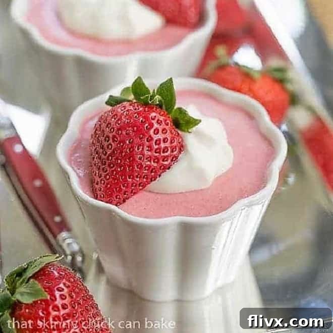 Strawberry Mousse - A sweet, creamy springtime berry dessert Strawberry Mousse in small white ramekins garnished with whipped cream and half a strawberry.