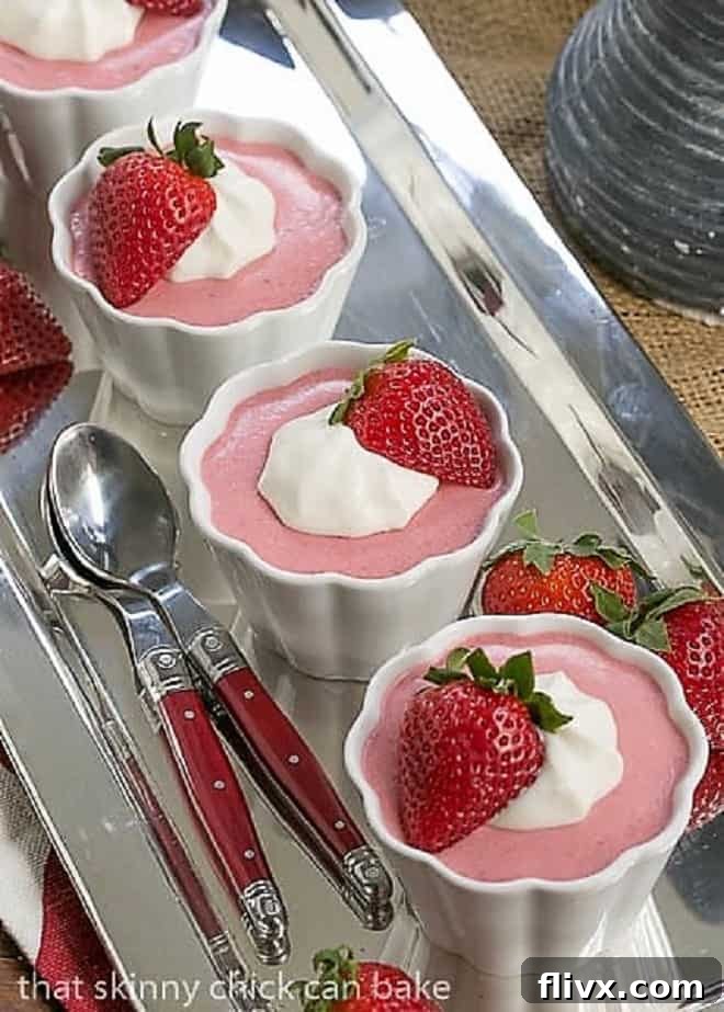 Effortless Strawberry Dream 2 Strawberry Mousse in 4 white ramekins lined up on a silver tray with red handled spoons.