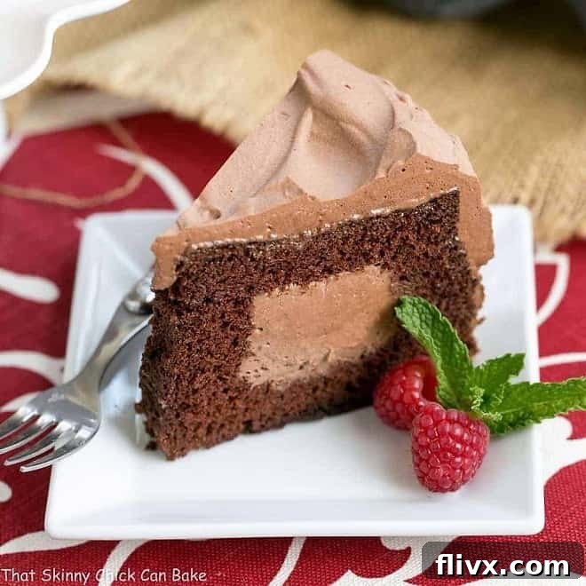 A perfectly sliced Tunnel of Mousse Cake on a square white dessert plate, showcasing the rich chocolate cake and creamy mousse filling.