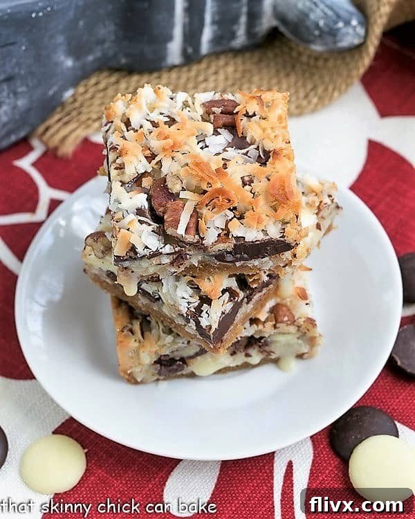 The Best Seven Layer Bars stacked on a round white plate, showcasing their distinct layers.