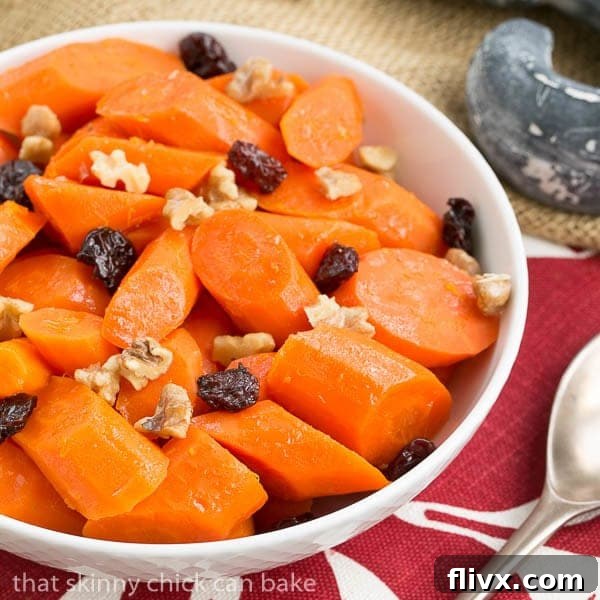 Orange Glazed Carrots in a white serving bowl, garnished with fresh herbs