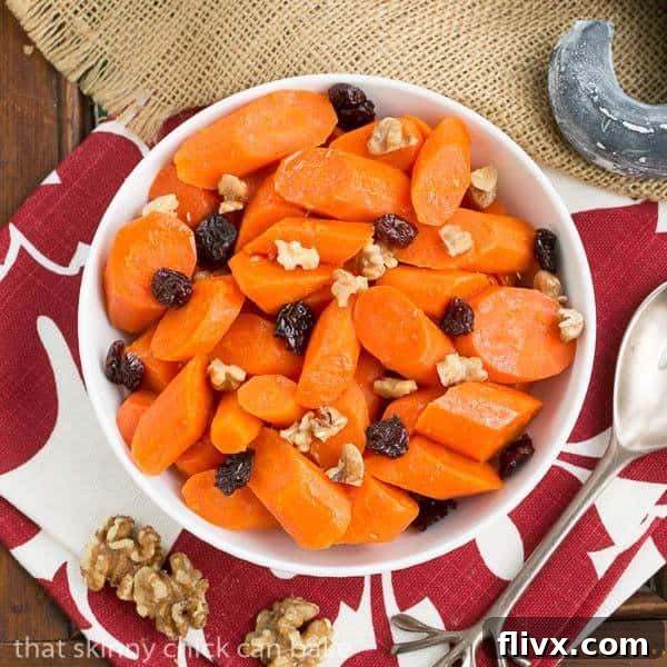 Overhead view of Orange Glazed Carrots in a serving bowl, showcasing the glaze, walnuts, and cranberries