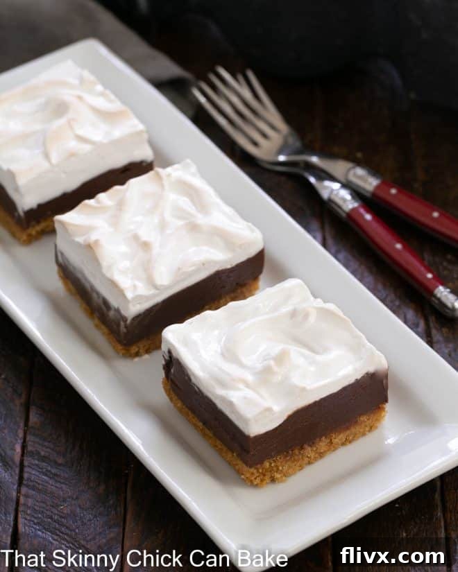 Dreamy Smores Fudge Bars 4 Three perfectly cut and artfully arranged S'mores Fudge Bars on a pristine white ceramic tray, accompanied by two forks, inviting immediate indulgence. The layers are clearly visible.