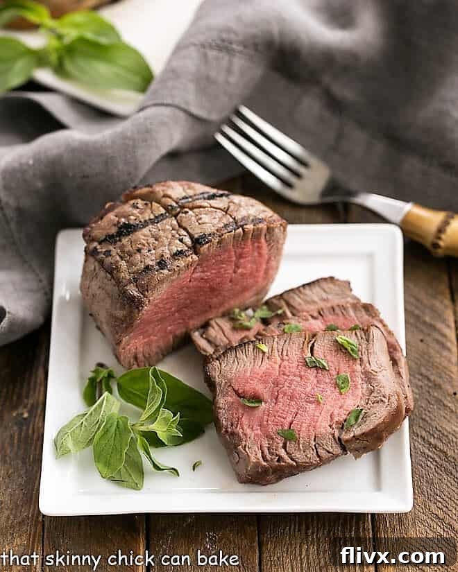 Garnished Grilled Steak with Garlic Herb Butter on a pristine square white plate, ready to be served.