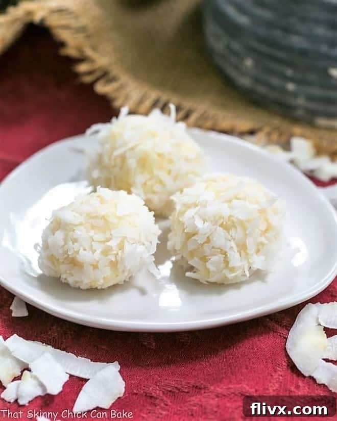 Coconut White Chocolate Truffles on an oval white plate, showcasing their pristine white coating and perfect spherical shape.