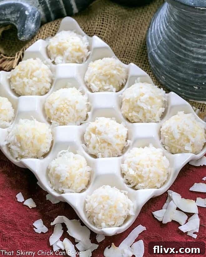 Coconut White Chocolate Truffles nestled in a rustic ceramic egg crate, showing off their textured coconut coating.