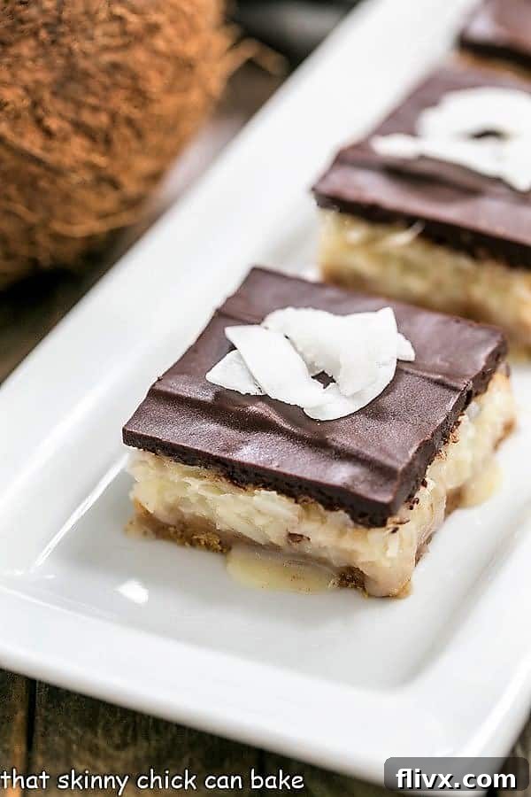 Delicious homemade Coconut Bars arranged beautifully on a white ceramic tray.