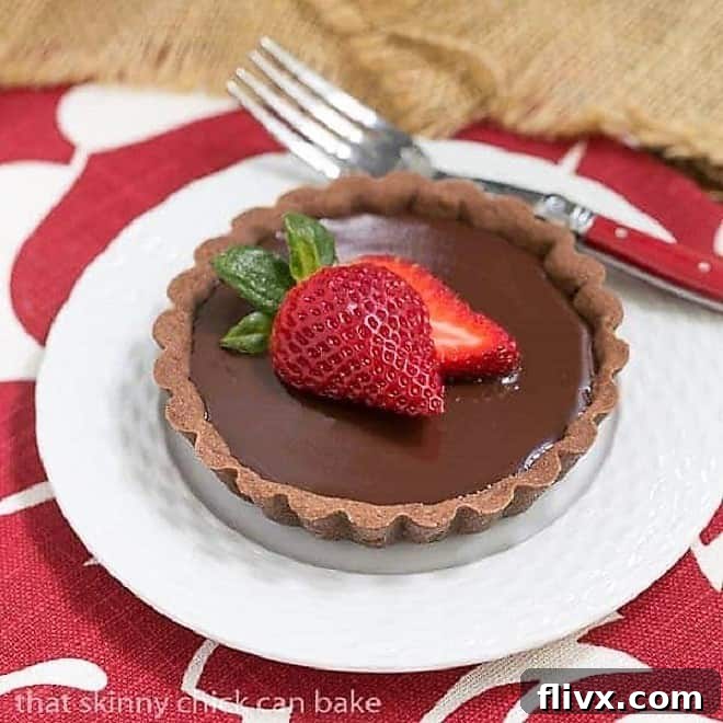 Double Chocolate Tartlet topped with a strawberry on a white plate