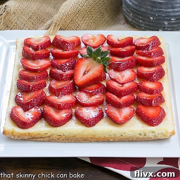 Close-up view of Strawberry Cheesecake Bars adorned with perfectly sliced, glazed berries.