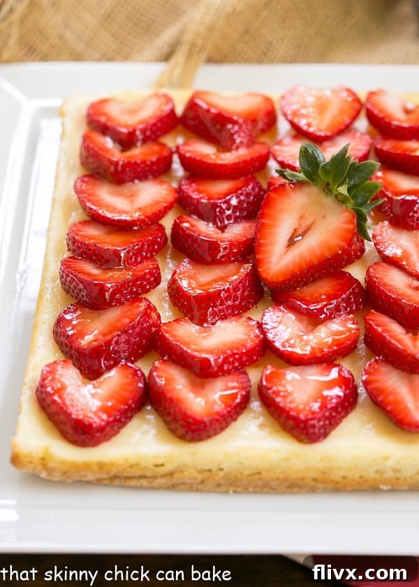A close-up, tempting view of Strawberry Cheesecake Bars artfully arranged on a pristine white ceramic platter.