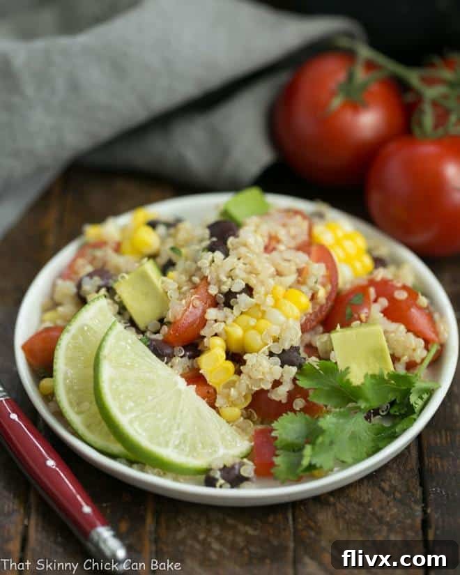 Close-up of Quinoa Black Bean Salad with Lime Cumin Vinaigrette on a small white plate, garnished with a lime wedge.