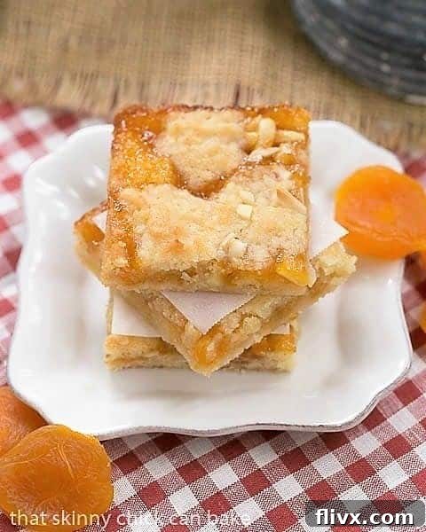 Coconut Apricot Bars beautifully garnished with dried apricot slices on a small square plate.