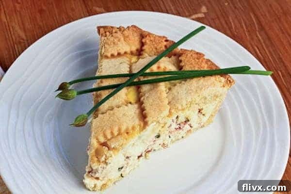 A whole Pizza Rustica presented on a pristine white plate, showcasing its golden-brown crust and inviting texture.