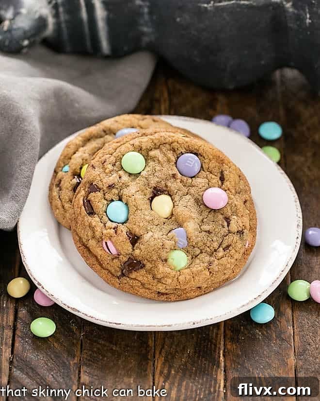 Two delectable Brown Butter Easter Cookies adorned with pastel M & M's, resting on a round white plate.