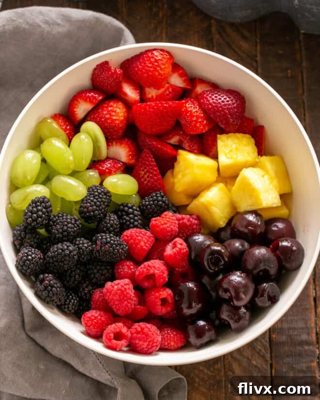 Add a variety of fruit to a mixing bowl.