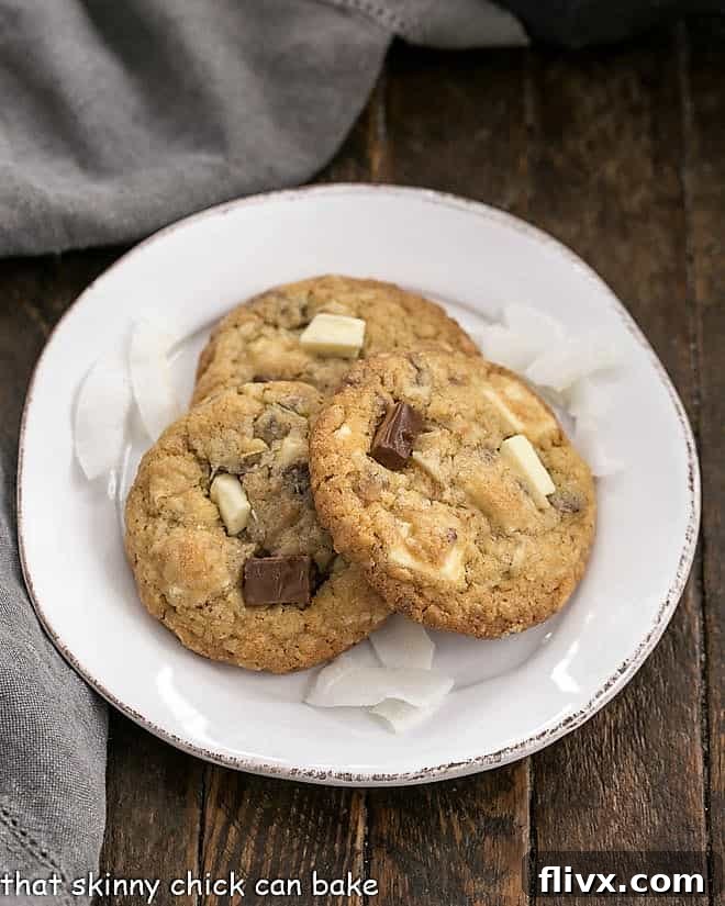 Three Chewy Oatmeal Toffee Cookies on a round white dessert plate.