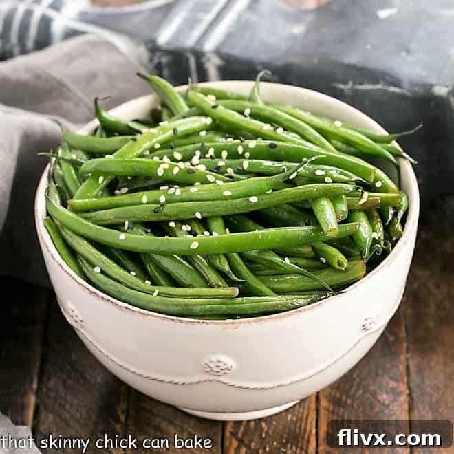 Delicious Asian green beans in a round serving bowl, garnished with sesame seeds.