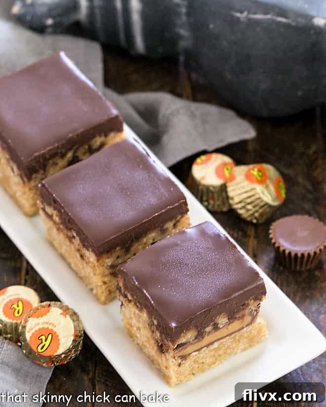 Three Stuffed Peanut Butter Rice Krispie Treats on a pristine white ceramic tray, showcasing their rich texture and alluring chocolate topping, promising an unforgettable taste experience for any dessert enthusiast.