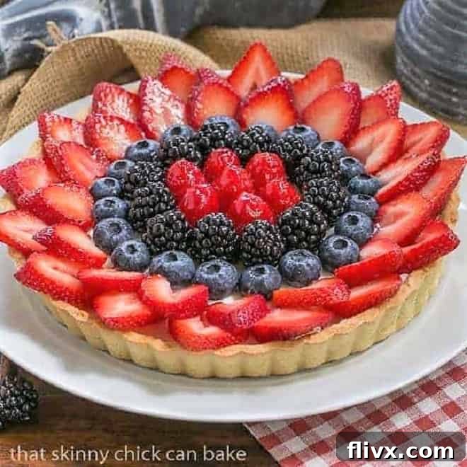 Vibrant Summer Fruit Tart on a pristine white serving plate, featuring a golden pastry crust, creamy filling, and a medley of fresh, colorful berries. Perfect for summer entertaining.