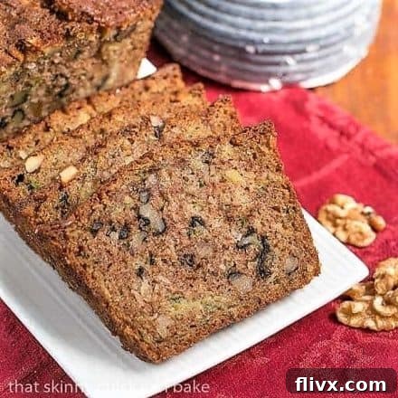Slices of moist pineapple coconut zucchini bread on a white tray, placed on a vibrant red napkin, highlighting its inviting texture.