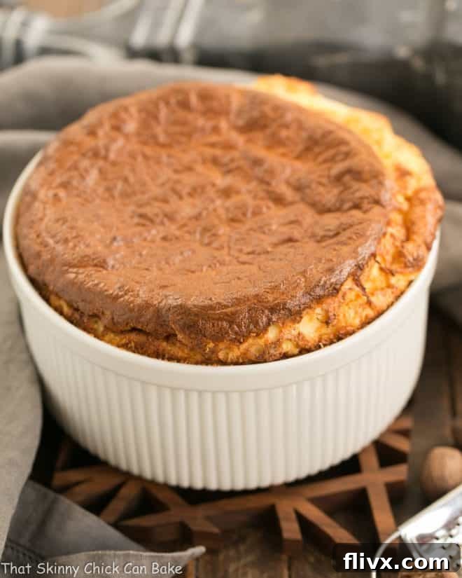French Gruyere Souffle in a white ceramic souffle dish, perfectly risen and golden brown