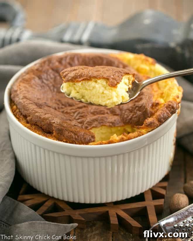 A spoonful of French Gruyere Souffle being served, showcasing its fluffy and irresistible texture