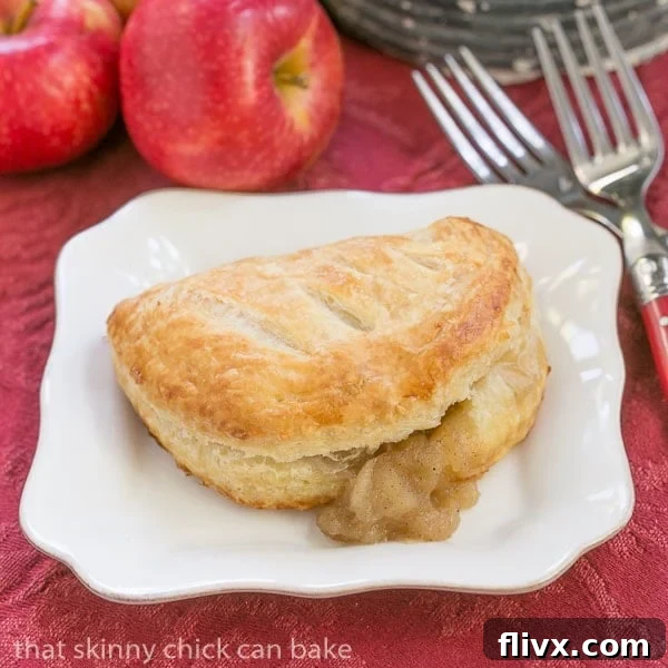 Chaussons aux Pommes with the delicious apple filling seeping out slightly, highlighting the rich texture.