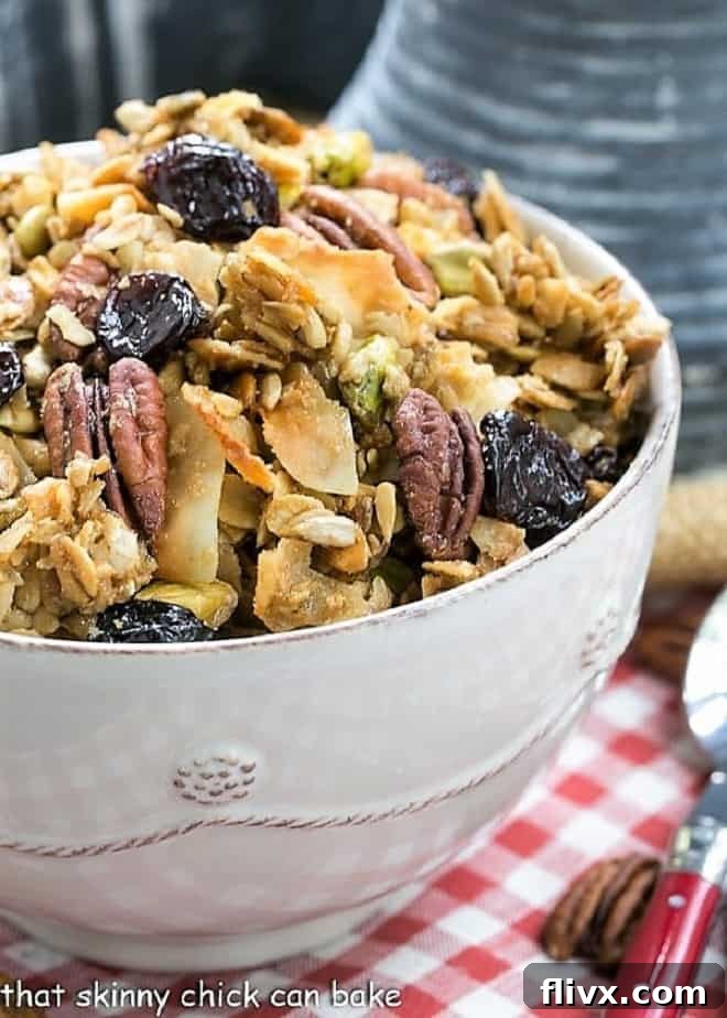 Homemade Maple Coconut Granola in a white ceramic bowl, showcasing its rich texture and ingredients.