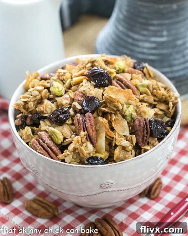 Maple Coconut Granola in a large white bowl on a checked napkin, ready to be served.
